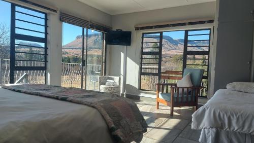 a bedroom with a bed and a view of a mountain at Skylight Guest House in Harrismith