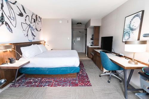 a hotel room with a bed and a desk and a computer at Hilton Garden Inn Fairfax in Fairfax