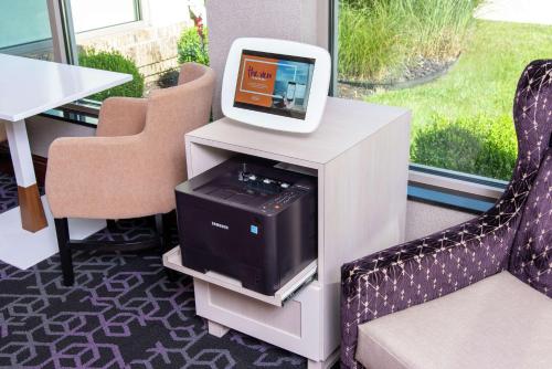 a tv sitting on top of a table with two chairs at Hilton Garden Inn Indianapolis South/Greenwood in Indianapolis