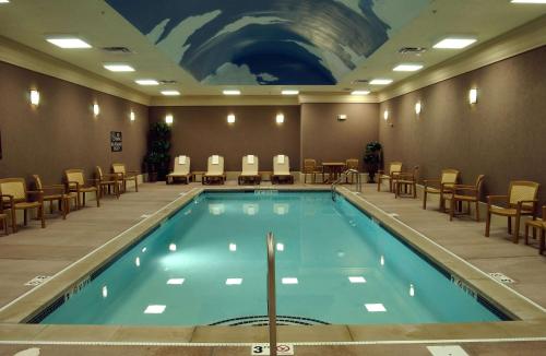 une grande piscine avec des chaises et un tableau mural dans l'établissement Homewood Suites by Hilton Indianapolis Downtown, à Indianapolis