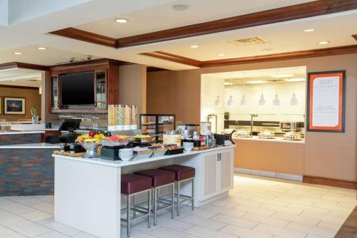 a restaurant with a counter with food on it at Hilton Garden Inn Indianapolis South/Greenwood in Indianapolis