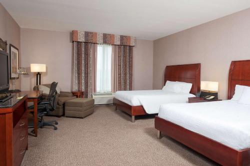 a hotel room with two beds and a desk at Hilton Garden Inn Indianapolis South/Greenwood in Indianapolis