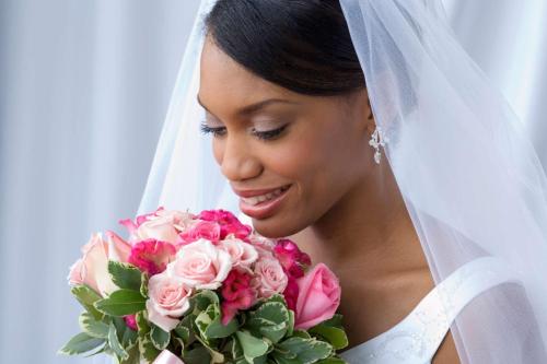 a bride holding a bouquet of pink roses at Homewood Suites by Hilton Indianapolis Downtown in Indianapolis