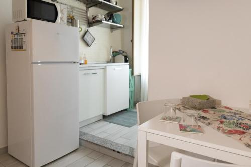 een keuken met een witte koelkast en een tafel bij Cortile Pace in Catania