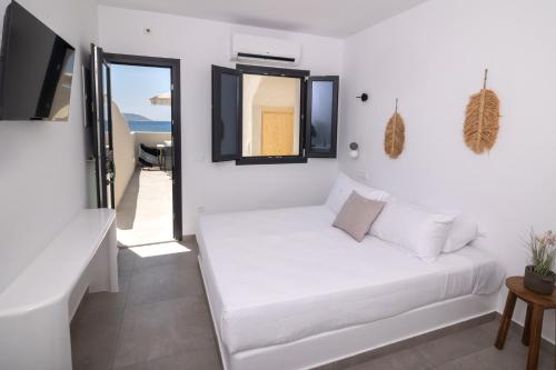 een witte kamer met een bed en een raam bij Anafi Drops Mare in Anafi