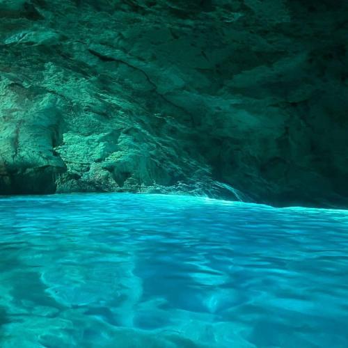 ein blauer Pool mit Wasser in einer Höhle in der Unterkunft Grotta verde Marina di andrano in Andrano