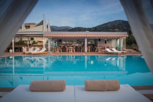 uitzicht op een zwembad met stoelen en een huis bij Notos Heights Hotel & Suites in Malia