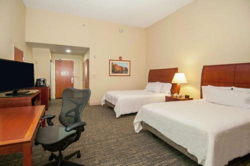 a hotel room with two beds and a desk and a chair at Hilton Garden Inn Jackson/Pearl in Pearl