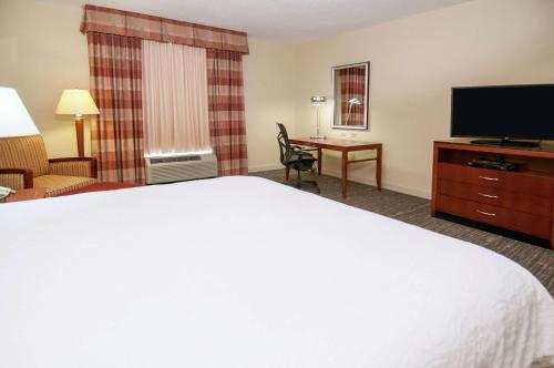 a hotel room with a bed and a flat screen tv at Hilton Garden Inn Jackson/Pearl in Pearl