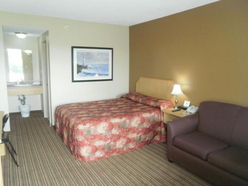 a hotel room with a bed and a couch at Bayview Inn Orillia in Orillia