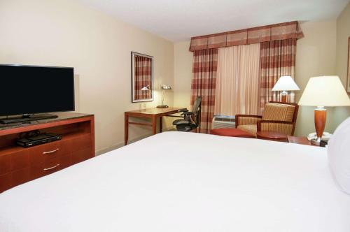 a hotel room with a bed and a flat screen tv at Hilton Garden Inn Jackson/Pearl in Pearl