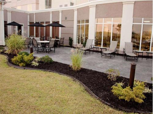 a patio with tables and chairs in front of a building at Hilton Garden Inn Jonesboro in Jonesboro
