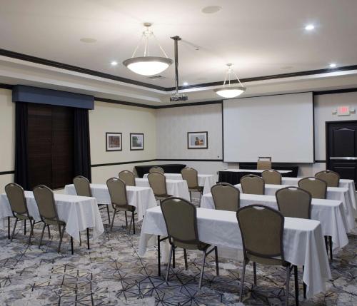 a conference room with tables and chairs and a whiteboard at Hilton Garden Inn Jonesboro in Jonesboro