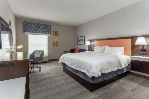 ein Hotelzimmer mit einem Bett und einem Schreibtisch in der Unterkunft Hampton Inn Jefferson City at Capital Mall in Jefferson City