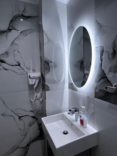 uma casa de banho com um lavatório e um espelho em The Gwen em Saranda
