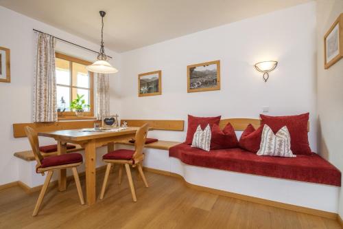 a living room with a red couch and a table at Weber am Gasteig in Reit im Winkl