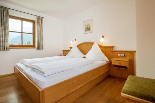 a bedroom with a large bed with white sheets at Weber am Gasteig in Reit im Winkl