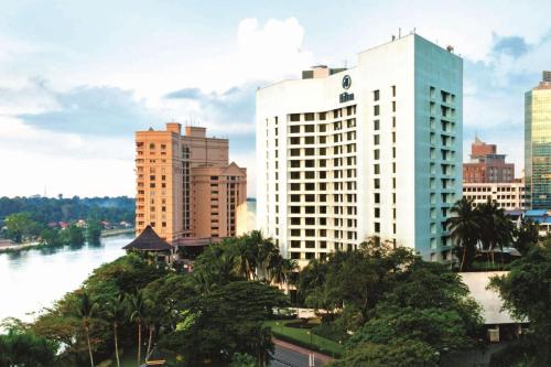 a view of a city with a river and buildings at Hilton Kuching Hotel in Kuching