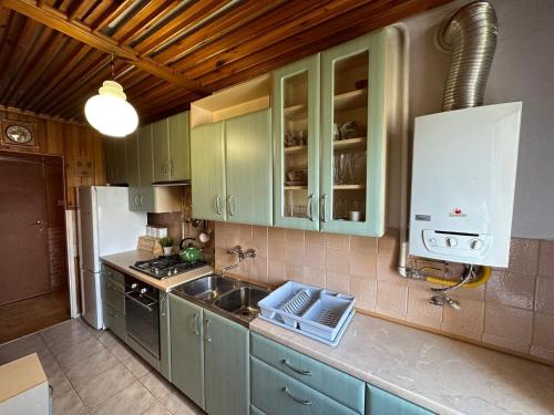 a kitchen with green cabinets and a sink at Przestronny apartament na wyłączność w centrum miasta - Mszana M11 in Mszana Dolna