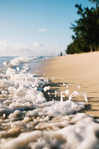 a beach with a plastic chair in the water at Sea La Vie - Holiday Home in Albion