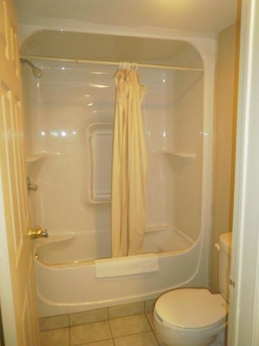 a bathroom with a tub and a toilet and a shower at Bayview Inn Orillia in Orillia