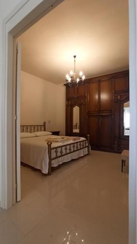 Habitación grande con cama y lámpara de araña. en Dimora CartaPane, en Ariano Irpino