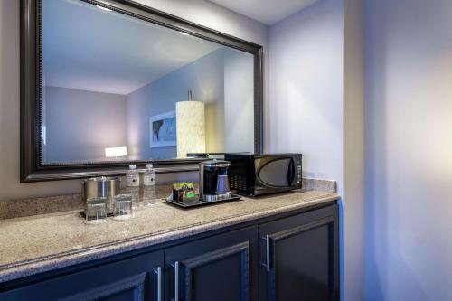 a bathroom with a counter with a microwave and a mirror at DoubleTree by Hilton Los Angeles Norwalk in Norwalk