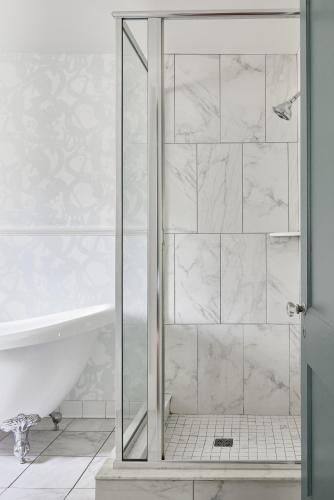 a shower with a glass door in a bathroom at Blind Tiger Asheville in Asheville