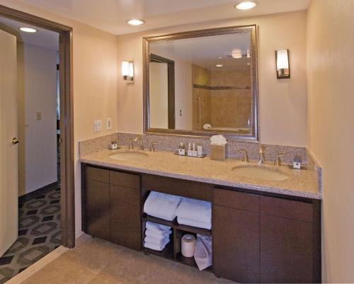 baño con 2 lavabos y espejo grande en DoubleTree by Hilton Rosemead, en Rosemead
