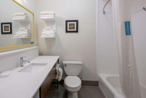 a white bathroom with a sink and a toilet and a tub at Hampton Inn and Suites Lafayette in Lafayette