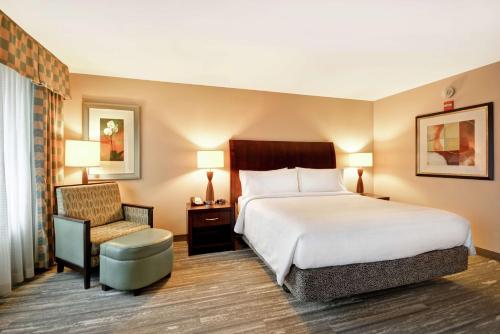a hotel room with a bed and a chair at Hilton Garden Inn Ridgefield Park in Ridgefield Park
