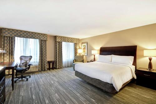 um quarto de hotel com uma cama grande e uma secretária em Hilton Garden Inn Ridgefield Park em Ridgefield Park