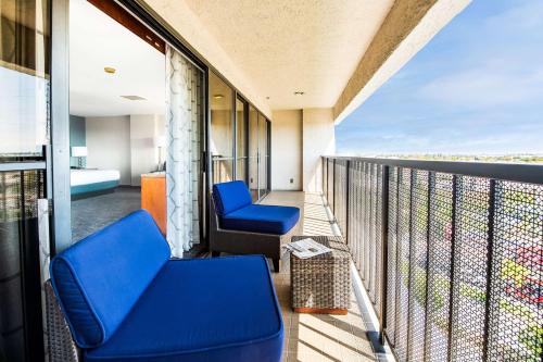 a balcony with blue chairs on a building at DoubleTree by Hilton Carson in Carson