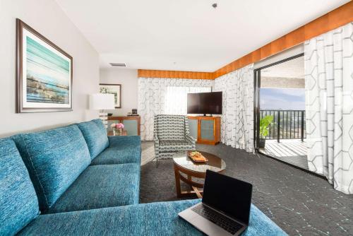 a living room with a blue couch and a laptop at DoubleTree by Hilton Carson in Carson