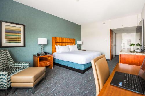 a hotel room with a bed and a chair and a desk at DoubleTree by Hilton Carson in Carson