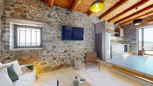 a living room with a stone wall at Petra Elounda Suites - Adults Only in Elounda