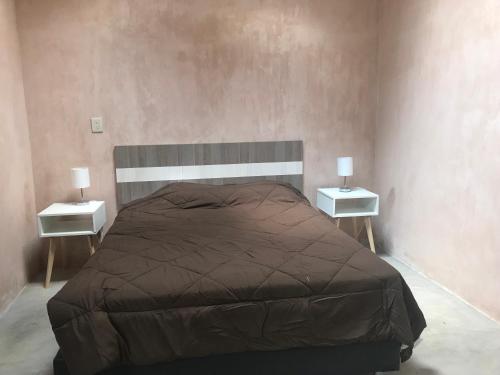 a bedroom with a large bed with two night stands at Quinta Lum in San Cristóbal de Las Casas