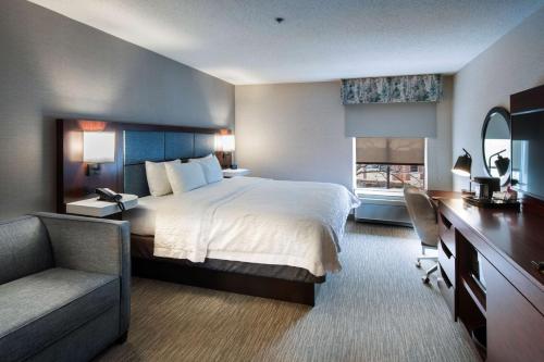 a hotel room with a bed and a desk and a chair at Hampton Inn & Suites Lincolnshire in Lincolnshire