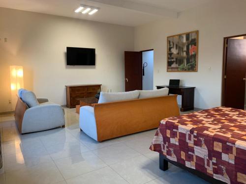 sala de estar con cama, sofá y silla en Cinco de Mayo Hotel, en Querétaro