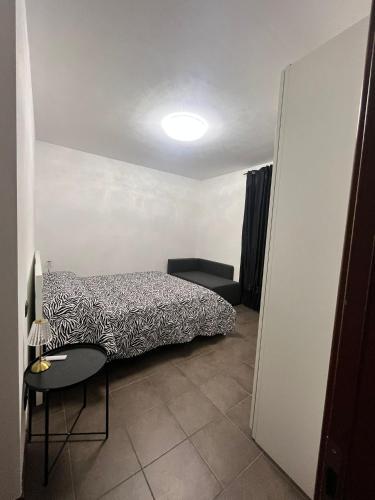 ein kleines Schlafzimmer mit einem Bett und einem Stuhl in der Unterkunft Home Sarenji in Trivolzio