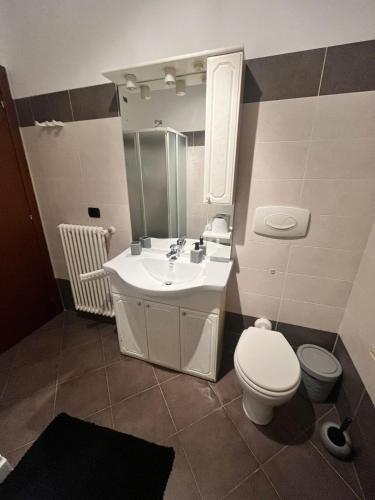ein Badezimmer mit einem Waschbecken, einem WC und einem Spiegel in der Unterkunft Home Sarenji in Trivolzio