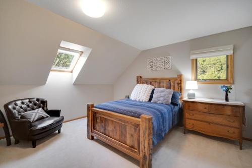 a bedroom with a wooden bed and a chair at Hidden Hollow in Bozeman