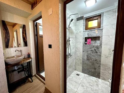 a bathroom with a walk in shower and a sink at Doğada ahşap minik bir ev. ( Nazende Dağ Evi ) in Akcaabat