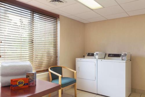 a laundry room with a washer and a table and a chair at Hilton Garden Inn Lancaster in Lancaster