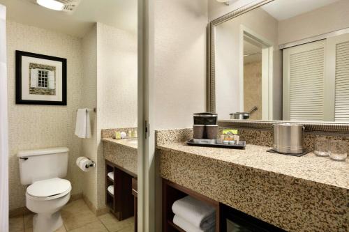 a bathroom with a toilet and a sink and a mirror at DoubleTree Resort by Hilton Lancaster in Lancaster