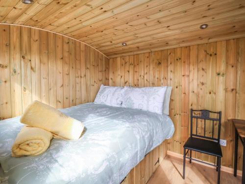 a bedroom with a bed in a wooden cabin at The Oak Hut in Whitchurch