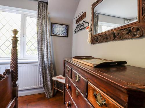 een kamer met een dressoir en een spiegel aan de muur bij Oak Meadow in Hastings
