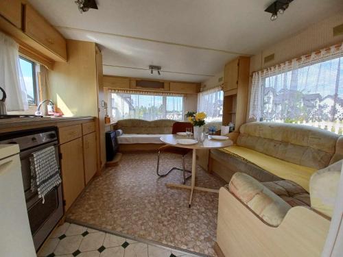 uma cozinha e uma sala de estar com um sofá e uma mesa em DOMEK holenderski, Ogród, blisko plaży, Gdynia WAKACJE NA LUZIE em Gdynia