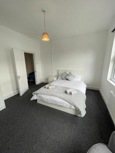 a white bedroom with a bed with white sheets at House by Araminta in Hounslow