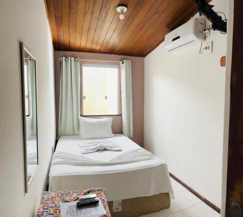 Cama pequeña en habitación con ventana en Pousada Timbalada en Morro de São Paulo